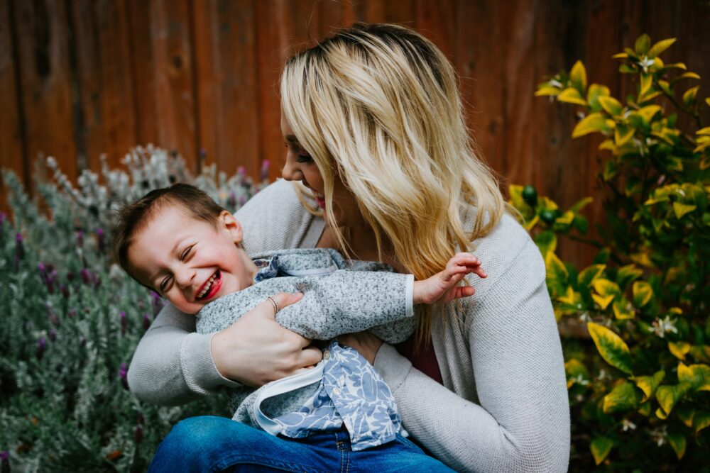 笑う赤ちゃんを抱っこする母親